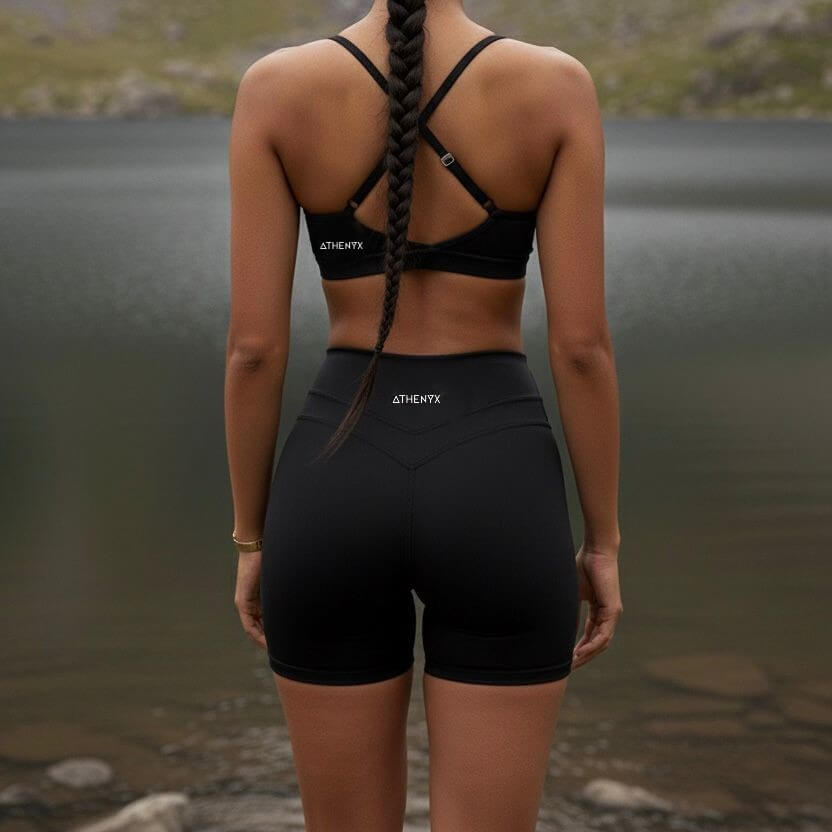 ATHENYX CORA Sports Bra - Supportive - Black/Navy - worn by a model by the river.