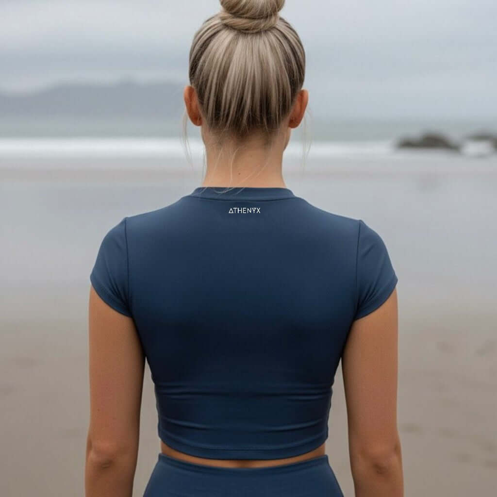 ATHENYX Women's CORA Crafted Short Sleeve Top - Stretch - Black/Navy back view on a beach.